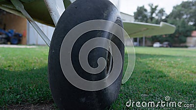 Closeup airplane wheel standing airfield grass. Plane chassis on green field. Stock Photo