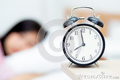 closeup alarm clock and beautiful asian young woman in morning, Stock Photo