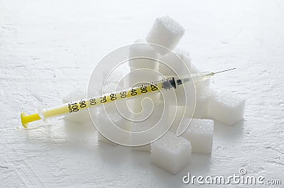 Closeup of amplty insulin syringe and pile of white sugar cubes on the white surface.Concept of metabolic disorders and special in Stock Photo