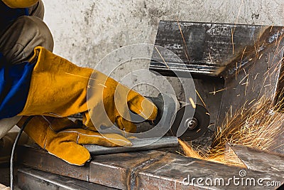 Closeup of a angle grinder being used to cut a notch inside a steel pipe. At a construction site Stock Photo