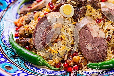 Closeup of an appetizing Uzbek national dish Plov, Pilaf made of rice and meat served with peppers Stock Photo