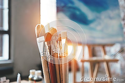 Closeup of artist paintbrushes and studio interior. Blurred background. Workshop or art class. Creative concept Stock Photo