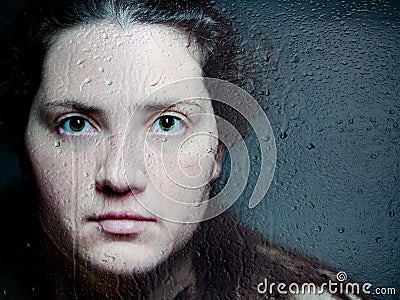 Closeup Artistic Portrait of Caucasian Woman Looking Through Woman Looking Through Glass with Water Drops and Tears Stock Photo
