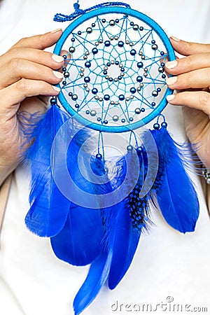 Closeup artistic woman posing holding dreamcatcher with bright blue feathers artwork Stock Photo