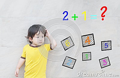 Closeup asian kid with confuse face by mathematic question on marble stone wall textured background Stock Photo