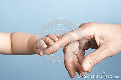 Closeup Of Baby Holding Man's Finger Stock Photo