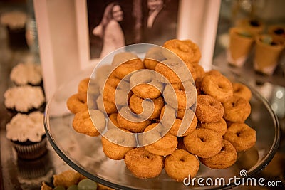 Closeup of baked mini donuts on a tray on the table during an event Stock Photo