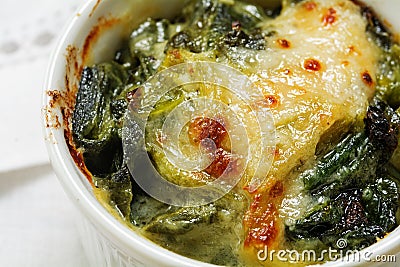 Closeup of baked spinach with cheese crust in a small casserole Stock Photo