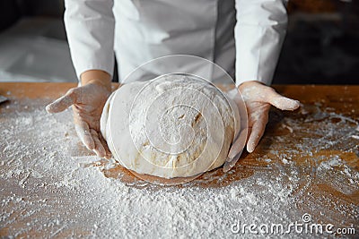 Closeup baker hands holding kneaded dough to prepare fresh bread Stock Photo