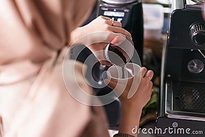 Closeup barista pour coffee into a cup. Stock Photo