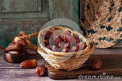 Closeup of a basket of delicious dates on a wooden surface with a blurry background Stock Photo