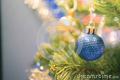 Closeup bauble hanging from a decorated Christmas tree on blurred background Stock Photo