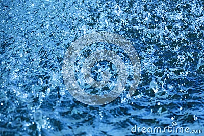 Closeup of beautiful dynamic water surface with falling droplets in blue color. Stock Photo