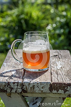 Closeup of a beer mug on old wood table top in sunlight Stock Photo