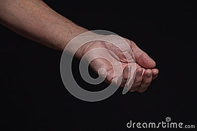 Closeup of a begging hand gesture on a black background Stock Photo