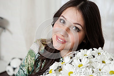 Closeup belly of pregnant woman, holding in hands bouquet of daisy flowers outdoors, new life concept Stock Photo