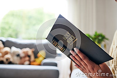 Closeup, bible and hands in home for faith, studying religion or mindfulness with holy spiritual scripture. Christian Stock Photo