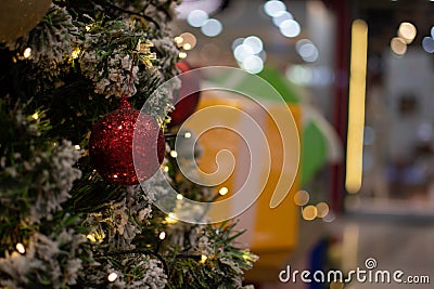 Closeup medium red balls Christmas tree decorated with small bulbs is beautiful. Christmas tree decoration with white snow, copy Stock Photo