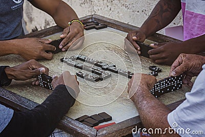 Closeup of black Latinos hands playing dominoes in the neighborhood of La Marina Matanzas, Cuba Stock Photo