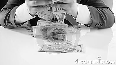 Closeup black and white image of greedy businessman grabbing and throwing big stack of money Stock Photo