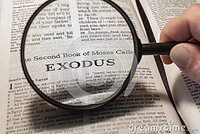 closeup of the book of Exodus from Bible or Torah using a magnifying glass to enlarge print. Stock Photo