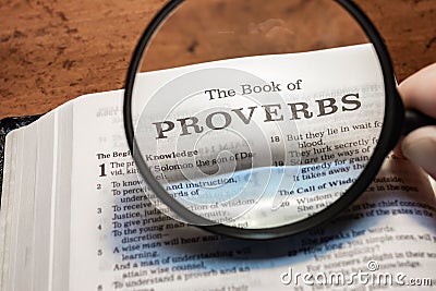 closeup of the book of Proverbs from Bible or Torah using a magnifying glass to enlarge print. Stock Photo