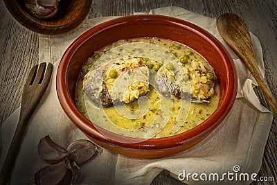 Closeup of a bowl of casserole of hake slices in green sauce with peas Stock Photo