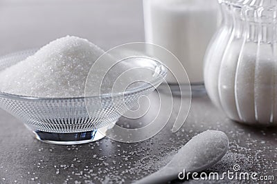 Closeup bowl and spoon with white sand on stone table background Stock Photo