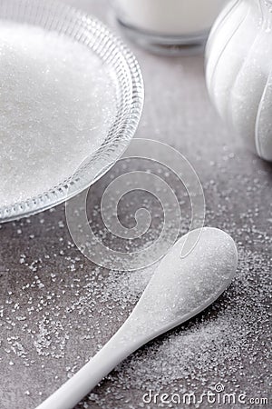 Closeup bowl and spoon with white sand on stone table background Stock Photo