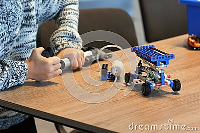 Closeup of boy`s hands pumping up the constructor and learning the basics of pneumatics at school. Robotics, STEM Stock Photo