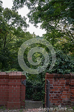Closeup of a brick fence and gate in a green park in Cottbus, Germany Stock Photo