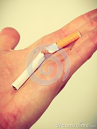 Closeup of broken cigarette on male hand. Stock Photo