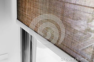 Closeup brown color Roller blinds curtains. sunlight through the windows in the city. Selective focus image Stock Photo