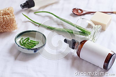 Closeup of a brown glass bottle around aloe leaves on a white cloth Stock Photo