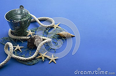 Closeup of bucket, amrine rope and net, seashell on the blue background.Empty space for design Stock Photo