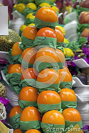 Bunch of persimmons in market stall Stock Photo