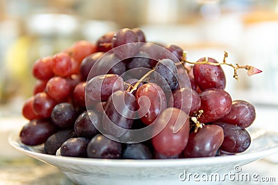 Closeup of a bunch of sweet, juicy grapes on a white plate Stock Photo