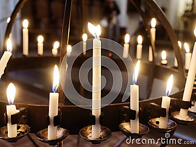 Closeup Burning candles on stand in church Stock Photo