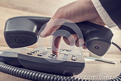 Closeup of businessman making a telephone call by dialing a phon Stock Photo