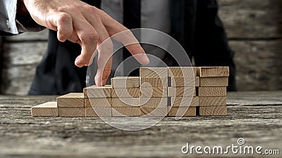 Closeup of businessman walking his fingers up wooden steps Stock Photo