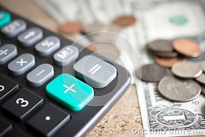 Closeup of calculator plus green button with money on wood board Stock Photo