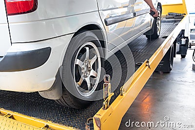 Closeup on car towed onto flatbed tow truck with cable Stock Photo