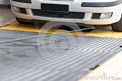 Closeup on car towed onto flatbed tow truck with cable Stock Photo