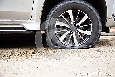 Closeup of car wheel flat tire on the road,car tire leak because of nail pounding on the street waiting for repair or changing Stock Photo