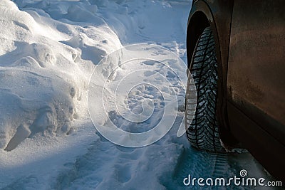 Closeup of car wheel on a snowy road at winter. Dangerous driving conditions Stock Photo