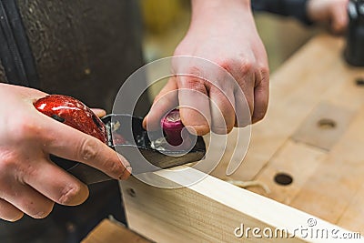 Closeup carpenter planing wood by hand with a planer Stock Photo