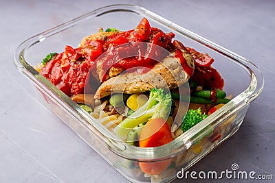 Closeup of a casserole of vegetables with chicken breast and sauce on a white surface Stock Photo