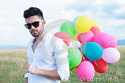 Closeup of casual man with balloons and sunglasses Stock Photo