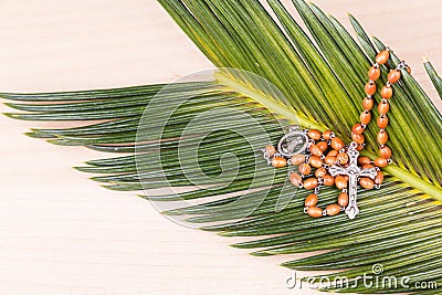 Closeup Catholic rosary with crucifix and beads on palm leaf Stock Photo