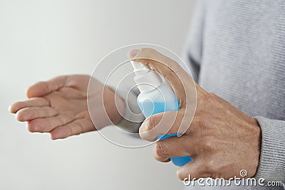 Man disinfecting his hands with hand sanitizer Stock Photo